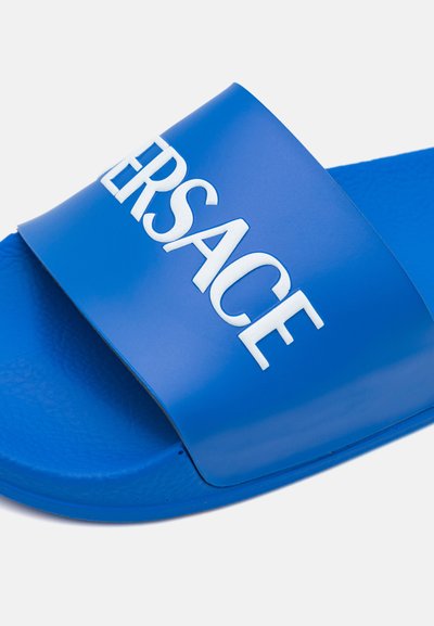 Blaue Rutschsandale aus glattem Gummi, mit einem großen weißen erhabenen Logo auf dem Riemen, strukturiertem Fußbett und runder Sohle.
