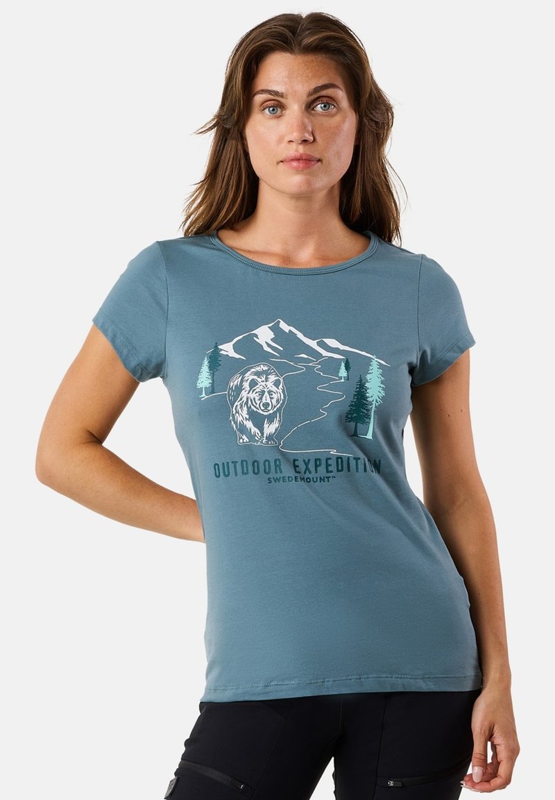 Light blue t-shirt made of soft cotton, featuring a graphic of mountains, trees, and a bear, with the text "Outdoor Expedition." Short sleeves.