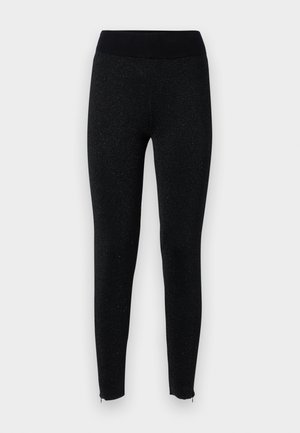 Schwarze Leggings mit einem gerippten Bund, aus strukturiertem Stoff mit einem subtilen metallischen Glanz, mit Reißverschlüssen an den Knöcheln.