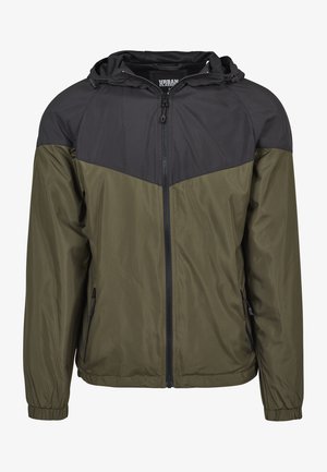Jachetă cu glugă, cu partea superioară neagră și secțiunea inferioară de culoare verde măslin, realizată dintr-un material ușor, cu fermoar frontal și manșete elastice.
