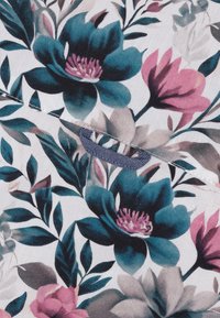 Bloemenstof met grote teal- en roze bloemen, groene bladeren op een witte achtergrond, met een blauwe gematteerde lus om op te hangen.