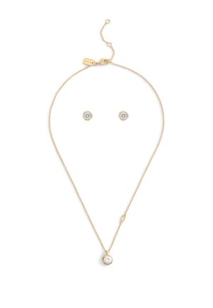 Set di gioielli in tonalità oro, composto da una delicata collana a catena con un pendente rotondo e orecchini a bottone, ciascuno decorato con una pietra trasparente.