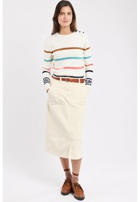 Pull rayé écru, avec des rayures marron, turquoise et rose. Assorti à une jupe claire et des chaussures marron, ceinturon texturé marron.