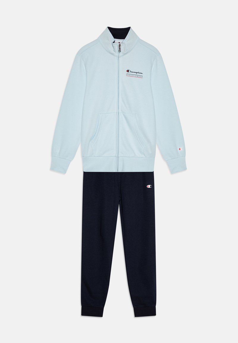Light blue zip-up jacket with high collar and front pockets, paired with navy sweatpants featuring cuffed ankles and logo accents.