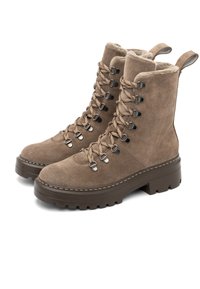 Par de botas de ante marrón con cordones, forradas de pelo, suelas de goma gruesa y ojales de metal, diseñadas para climas fríos.