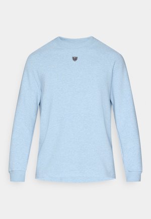 Svijetloplšna majica dugih rukava s rebrastim okruglim izrezom i teksturiranom tkaninom. Sadrži mali crni logo na prsima.