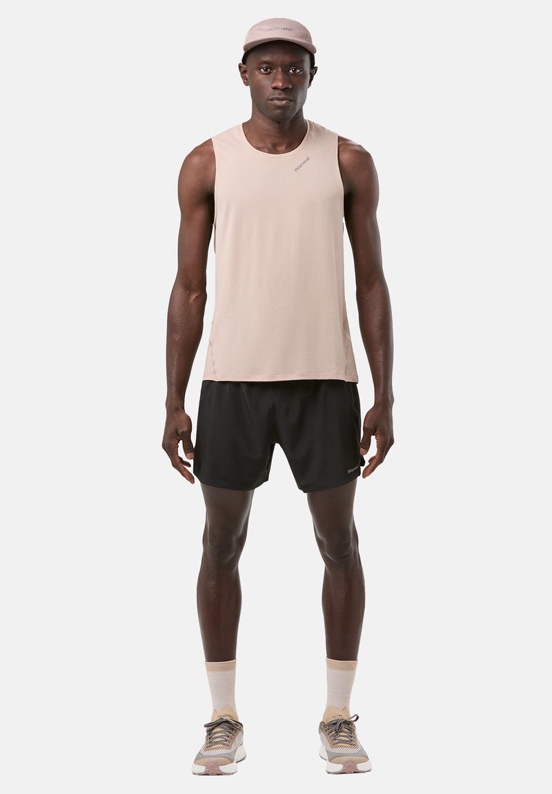 Light beige sleeveless athletic top with textured fabric and black shorts. Paired with a matching cap and shoes with beige, gray, and white accents.