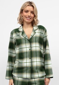 Groene geruite pyjama-set met een knoopsluiting, lange mouwen en een contrasterende kraag en manchetten, gemaakt van een zachte stof.