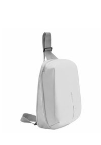 Sac à épaule gris au design épuré, avec un extérieur rembourré, une bandoulière ajustable et un logo minimaliste sur le devant.