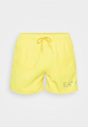 Kergedest materjalist kollased ujumispüksid, millel on elastne vöökoht ja nöör, ning ees prinditud logos.