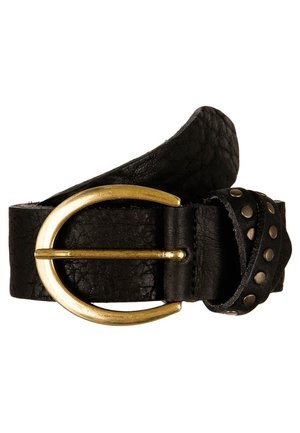 Zwarte leren riem met een afgeronde messing gesp en metalen studs langs het overlappende uiteinde van de riem, opgerold tegen een witte achtergrond.