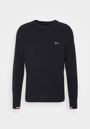 Maglione nero manica lunga con scollo rotondo in tessuto strutturato, piccolo logo Mercedes bianco e logo rosso-bianco Tommy Hilfiger sul petto, dettagli a righe sui polsini.