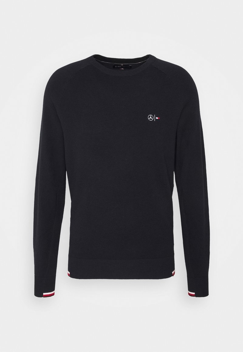Pull noir à manches longues col rond avec tissu texturé, petit logo blanc Mercedes et logo rouge et blanc Tommy Hilfiger sur la poitrine, et détails de poignets rayés.