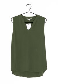 Olivgrön ärmlös topp med V-hals, tillverkad av lätt tyg. Har en något längre bakre fåll och en liten etikett fäst.