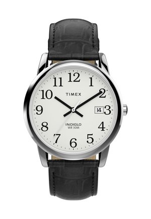 Reloj de pulsera Timex con caja redonda en tono plateado, esfera blanca, números arábigos negros, correa de cuero negra y función de fecha a las 3 en punto.