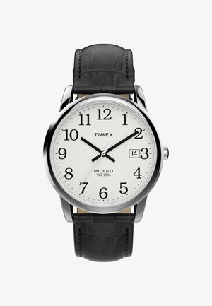 Ceas de mână Timex cu carcasă rotundă de culoare argintie, față albă, cifre arabe negre, curea din piele neagră și funcție de date la ora 3.
