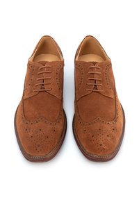 Zapatos de vestir de ante marrón con acentos perforados y diseño de cordones. Punta redondeada y suela de cuero marrón contrastante.
