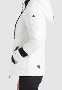 Doudoune blanche avec capuche, présentant des accents noirs sur les poignets et la fermeture éclair, texture matelassée et poches latérales. Logo cousu au bas.