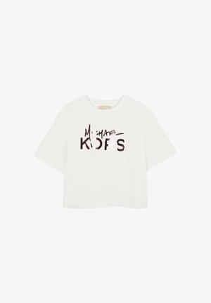 T-shirt blanc à manches courtes avec le logo "Michael Kors" imprimé en grandes lettres stylisées sur le devant.