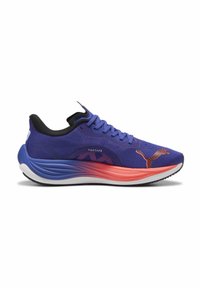 Zapatilla deRunning con un upper de malla morada, detalles negros y una entresuela en degradé que transita del azul al rojo. Cuenta con un logo prominente.
