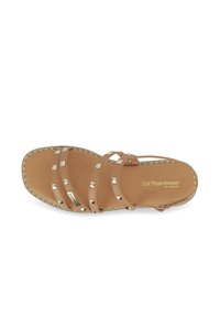 Sandalo piatto marrone con tre cinghie decorative caratterizzate da borchie in tono oro, punta quadrata e una soletta testurizzata. Il logo del marchio è visibile.