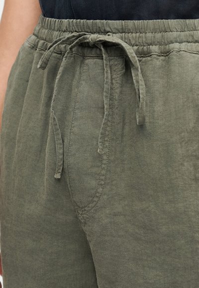 Pantalon en lin vert olive doté d'une taille élastique avec cordon de serrage, poches latérales, et coupe décontractée avec des détails de couture visibles.