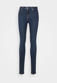 Jeans ajustados de mezclilla azul oscura. Cintura alta, diseño estándar de cinco bolsillos, con costuras detalladas y cierre de botón.