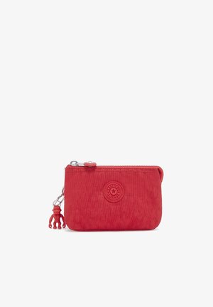 Portafoglio in nylon rosso con finitura texture, forma arrotondata, chiusura con zip e un piccolo charm a forma di scimmia in gomma attaccato. Presenta il logo sul davanti.