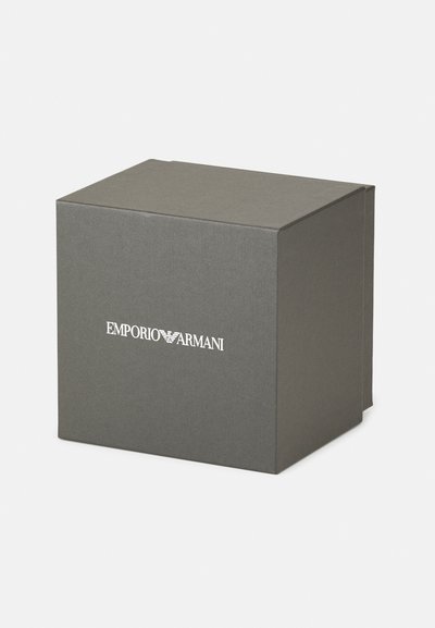 Szara sztywna pudełko o matowym wykończeniu, z białym logo "Emporio Armani" z przodu. Kwadratowy kształt, czysty design, bez widocznych akcentów.