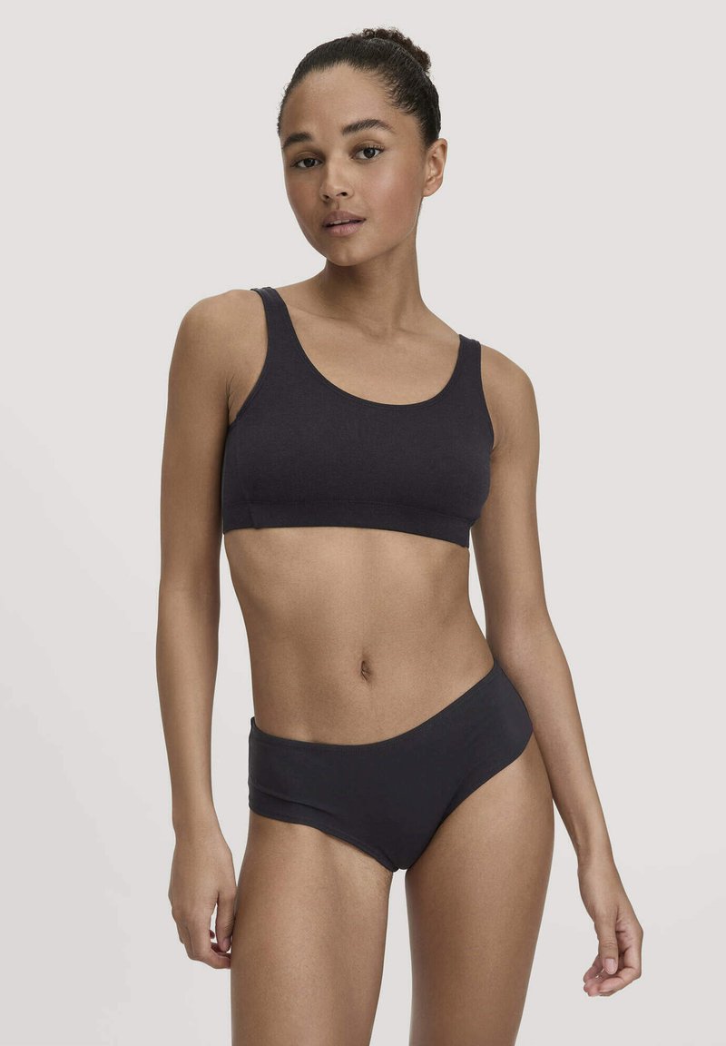 Zwarte katoenen sportbeha met brede bandjes, ronde halslijn en bijpassende zwarte hipsteronderbroek. Glad textuur en aansluitend ontwerp.