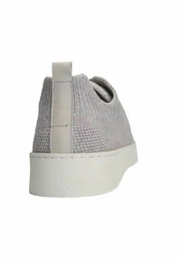 Grijze gebreide sneaker met een gestructureerde bovenkant, witte rubberen zool en een lus aan de achterkant voor gemakkelijk aan- en uittrekken. Zijkanten open voor ademend vermogen.