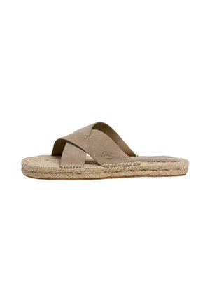 Sandalo beige slip-on con cinturini incrociati in suede e suola intrecciata in juta, stile piatto per un uso casual.