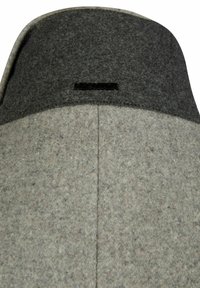 Sombrero gris con un ala de un gris oscuro. Presenta un borde cosido y una etiqueta de logo negra en la parte frontal. Textura suave y forma estructurada.