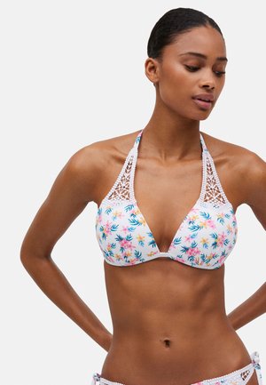Top de bikini floral con fondo blanco, con cuello halter, detalles de ganchillo y patrones florales en colores rosa brillante y verde.