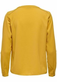 Haut jaune à manches longues avec un tissu texturé. Encolure arrondie et détails de boutons aux poignets. Finition lisse. Vue de dos affichée.