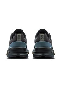 Chaussures de sport noires et bleues avec une tige en maille texturée, semelle rembourrée et logo distinctif au talon. Semelle extérieure en caoutchouc durable.