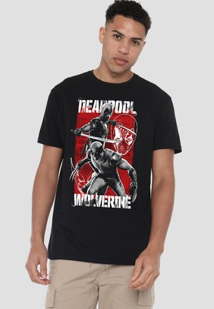 Black cotton t-shirt featuring a graphic print of Deadpool and Wolverine, highlighted against a red background with bold white text.