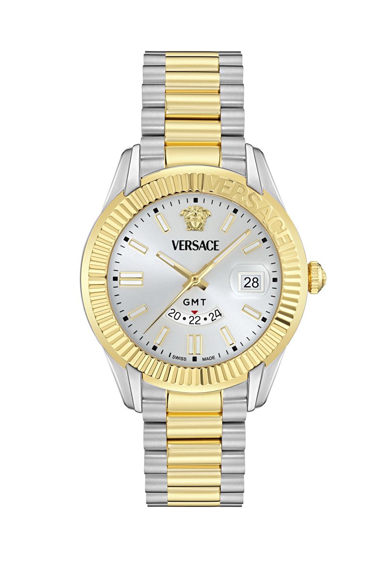 Reloj Versace con esfera plateada, acentos dorados y pulsera de acero inoxidable en dos tonos. Presenta una ventana de fecha y función GMT.