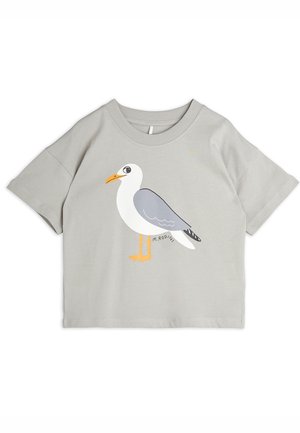 Chemise gris clair à manches courtes avec un dessin humoristique de mouette avec un corps blanc, des ailes grises, un bec et des pattes orange au centre devant.