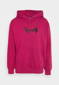Felpa rosa realizzata in morbido tessuto, con tasca frontale, cappuccio con cordino e grafica del logo nera sul petto. Maniche lunghe con polsini a costine.