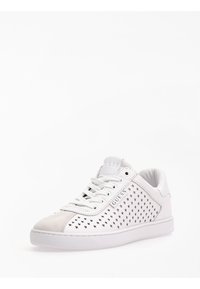 Sneaker bianco con perforazioni a forma di stella, punta in suede, logo sulla linguetta, lacci piatti e suola in gomma. Texture liscia con design uniforme.