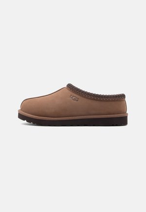 Brun ruskind slip-on sko med vævet overdel, rundet tå og en tekstureret mørk gummisål. Præget logo på siden.