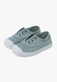 Světlé zelené plátěné slip-on boty s gumovými podrážkami, elastickými bočními panely a bílými špičkami. Obsahují kovové průvleky po stranách.