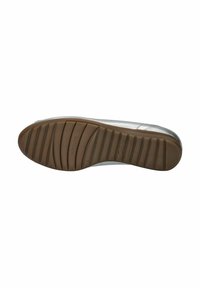 Suela de un zapato con una base de goma marrón flexible y estriada, con surcos texturizados, y material plateado visible en el borde.