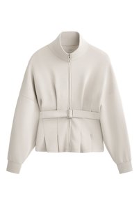 Vaaleanbeige vetoketjullinen takki, jossa on korkea kaulus, pleatattu muotoilu vyötäröllä ja vyöllä varustettu yksityiskohta. Pehmeää kangasta, jossa on joustavat hihansuut.