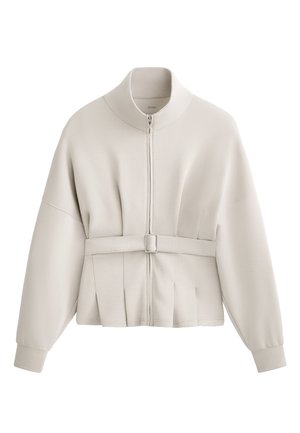 Jachetă crem deschis cu fermoar, guler înalt, design plisat la talie și accent cu curea. Material moale cu mansete elastice.