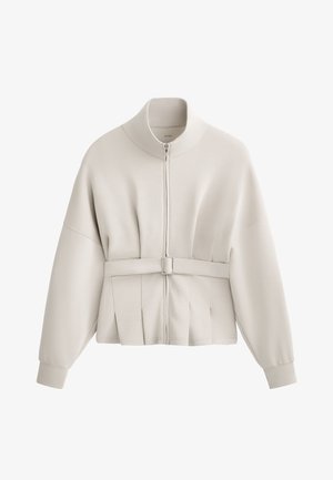 Jachetă crem deschis cu fermoar, guler înalt, design plisat la talie și accent cu curea. Material moale cu mansete elastice.