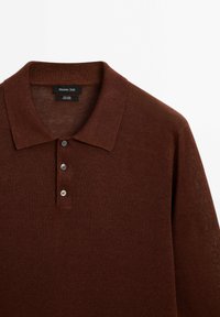 Polo shirt in lino marrone con colletto a coste, pattina con tre bottoni e texture a maglia fine. Etichetta che riporta "Massimo Dutti, 100% lino."