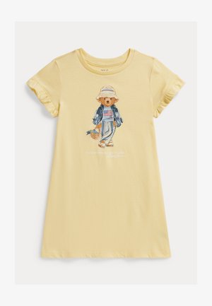 Κίτρινο βαμβακερό μπλουζάκι με φουσκωτά μανίκια, με εκτύπωση αρκούδας σε τζιν και καπέλο, που κρατάει ένα καλάθι. Casual εφαρμογή.