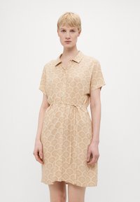 Short-sleeve dress in beige fabric with a shell pattern. Features a button-down front and a drawstring waist for adjustable fit.